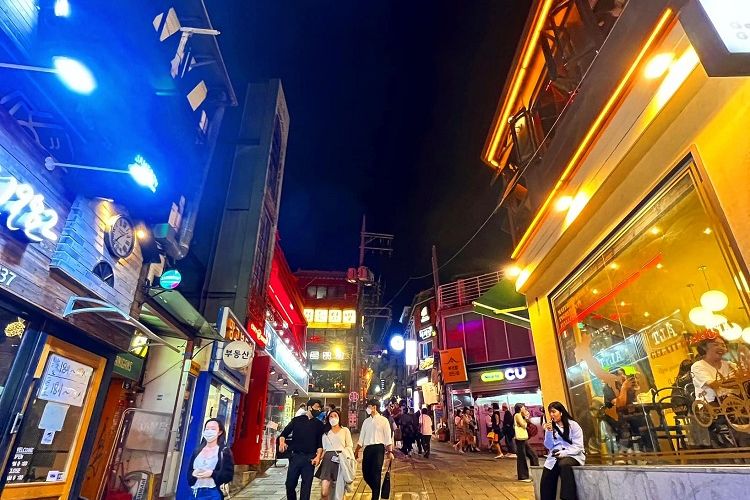 Pengunjung melintas di salah satu jalan kecil di distrik dunia malam Seoul di Itaewon, Jumat malam (30/9/2022). Jalan-jalan kecil dan gang-gang sempit mendaki yang penuh dengan kerumunan manusia yang nongkrong di bar dan kelab malam merupakan ciri khas Itaewon.