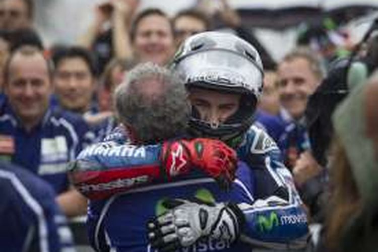 Pebalap Yamaha asal Spanyol, Jorge Lorenzo, memeluk kepala krunya, Ramon Forcada, saat merayakan kemenangan pada balapan GP Aragon di Sirkuit MotorLand Aragon, Minggu (28/9/2014).