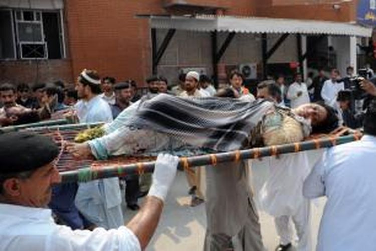 Seorang penumpang bus yang menjadi korban serangan bom di Peshawar, Pakistan tengah ditandu untuk dibawa ke rumah sakit. Sebuah bus yang mengangkut puluhan pegawai negeri di Peshawar terkena serangan bom, menewaskan 15 orang.