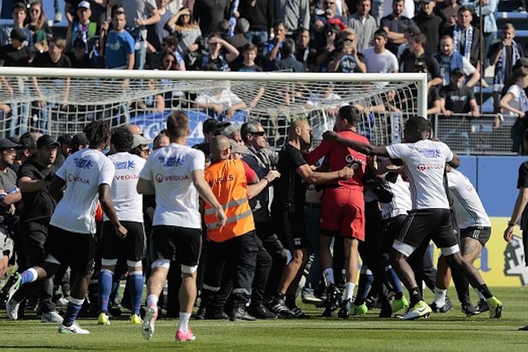 Para suporter Bastia mencoba menyerang kiper Lyon, Anthony Lopes, seusai babak pertama pertandingan Ligue 1 di Stadion Armand Cesari, Minggu (16/4/2017). 