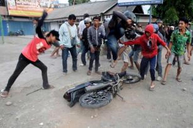 Warga merusak motor milik mahasiswa Universitas Muhammadiyah Makassar saat terjadi kerusuhan dengan mahasiswa di Jalan Sultan Alauddin, Makassar, Selasa (18/11/2014). Kerusuhan terjadi karena warga marah dengan mahasiswa yang menutup jalan saat berunjuk rasa memprotes kenaikan harga bahan bakar minyak.