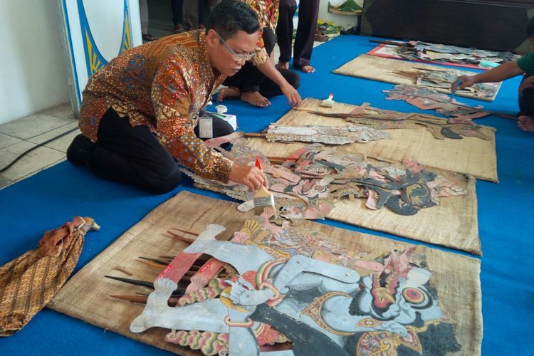 Petugas Museum Radya Pustaka Solo membersihkan koleksi wayang peninggalan PB II dan X di museum setempat di Solo, Jawa Tengah, Rabu (19/9/2018). Ngisis wayang rangkaian kegiatan 'Suro Bulan Kabudayaan Tahun 2018' yang digelar Museum Radya Pustaka sejak 12 September 2018 hingga 11 Oktober 2018.