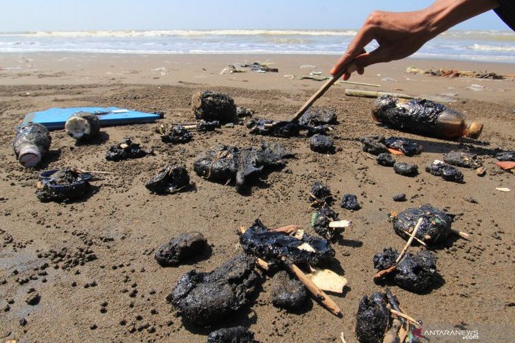 Warga menunjukkan sejumlah gumpalan-gumpalan berwarna hitam yang diduga minyak mentah di kawasan pantai Desa Tambak, Indramayu, Jawa Barat, Senin (7/6/2021). Gumpalan-gumpalan kecil berwarna hitam tersebut berserakan di bibir pantai sepanjang lima kilometer.