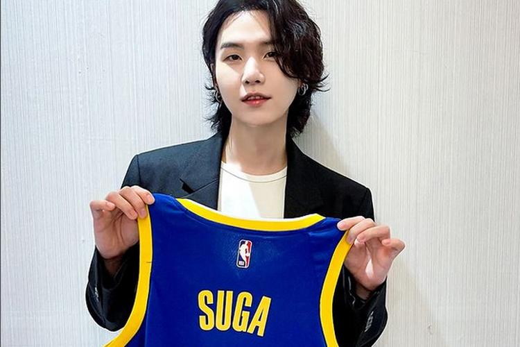 Suga BTS memamerkan jersey Golden State Warriors bertuliskan namanya.