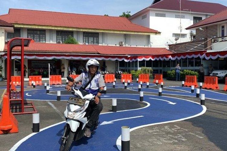 Peserta ujian praktik SIM C sedang mengendarai sepeda motor melintasi jalur S yang telah disediakan oleh petugas di Kantor Sat Lantas Polrestabes Medan di Jalan Adinegoro, Kota Medan, Senin (7/8/2023).  
