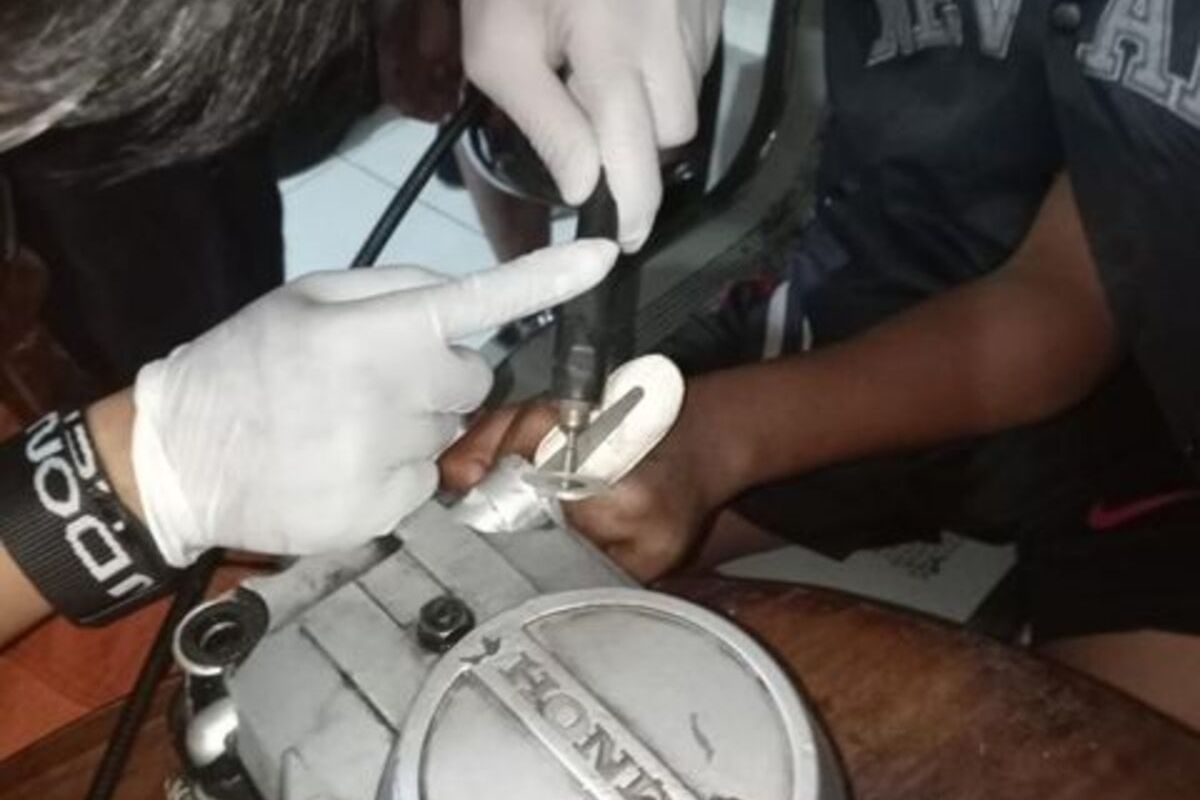 Fokus petugas Rescue Pemadam Kebakaran Surabaya ketika berusaha melepaskan jari pemuda yang terjpit di mesin motornya, Selasa (31/1/2023)