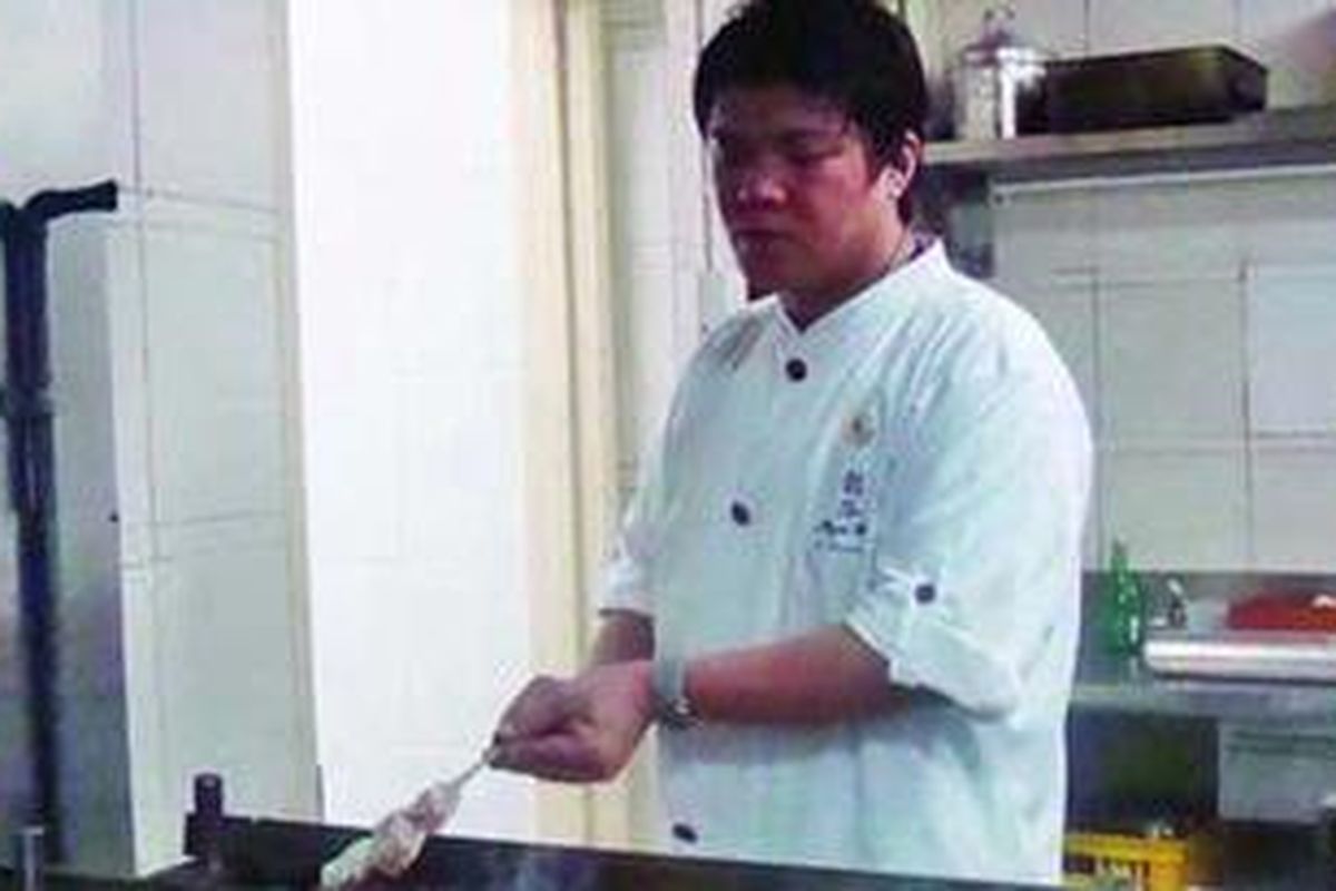 Chef Seiji Yamamoto tengah memanggang ikan yang dilapisi nasi dengan bahan-bahan dan kayu bakar yang dibawa dari Jepang.