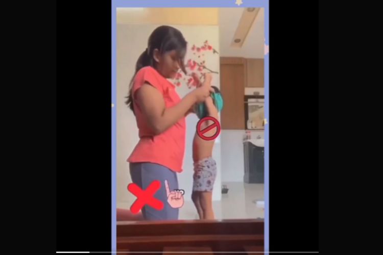 Tangkapan layar video cara melepas baju dari anak.