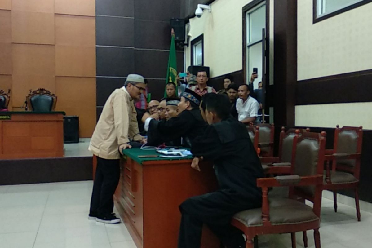 Jonru Ginting berdiskusi dengan kuasa hukumnya setelah mendengar vonis hakim, Junat (2/3/2018)