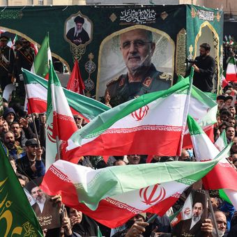Warga Iran mengibarkan bendera negara saat menghadiri pemakaman para komandan Korps Garda Revolusi Iran (IRGC) yang tewas dalam serangan Amerika Serikat-Israel, di Lapangan Enghelab, Teheran, 11 Maret 2026.