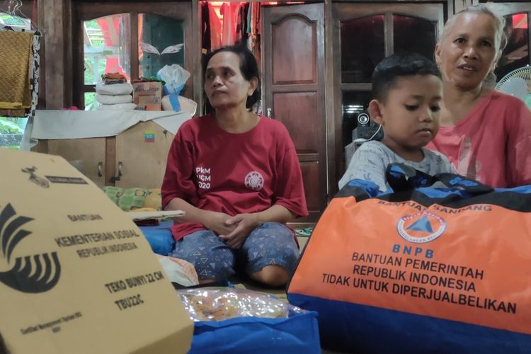 Jumini (65) di tengah puing rumah yang han ur akibat tanah longsor di Pedukuhan Plampang II, Kalurahan Kalirejo, Kapanewon Kokap, Kabupaten Kulon Progo, Daerah Istimewa Yogyakarta, Jumat (1/6/2022) malam.