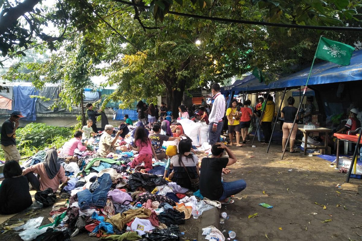 Para pengungsi korabn kebakaran Pasar Gembrong, Cipinang Besar Utara, Jatinegara, Jakarta Timur, tengah memilah pakaian laik pakai yang diberikan oleh relawan, pada Sabtu (30/4/2022).