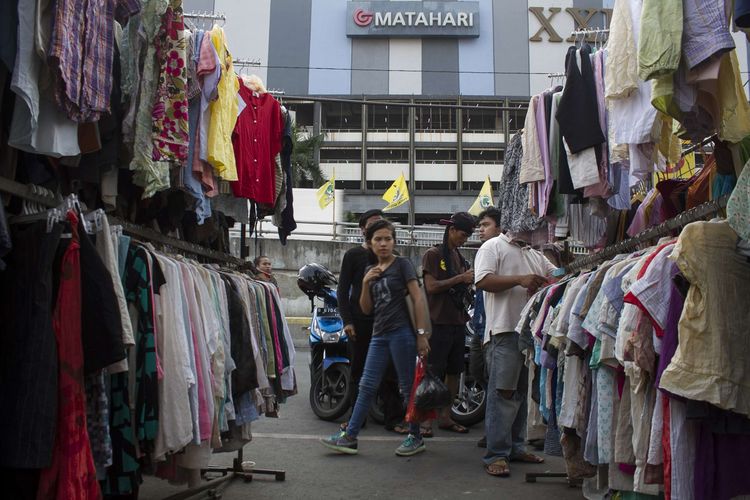 Pembeli memilih baju bekas yang dijual di bahu jalan depan Pasar Senen, Jakarta Pusat, (4/12/2019). Beberapa pedagang menolak direlokasi ke Pasar Kenari dan Pasar Atom karena khawatir usahanya tidak selaris di Senen.