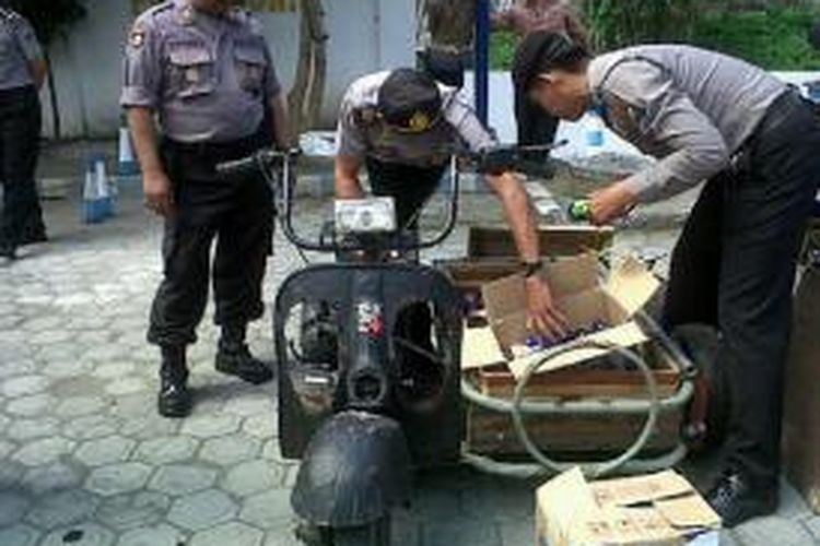 Aparat Polres Blitar memeriksa botol-botol arak yang dimasukkan kotak yang dipasang di sebuah Vespa, di Blitas, Jawa Timur, Jumat (19/7/2013). 
