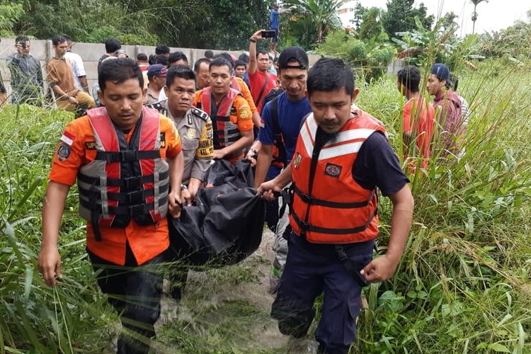 Tim Basarnas Pekanbaru, kepolisian dan pemadam kebakaran mengevakuasi jasad Yeni (25) yang ditemukan tewas setelah hanyut di parit di Jalan Swadaya, Kelurahan Delima, Kecamatan Tampan, Pekanbaru, Riau, Selasa (18/6/2019). Dok. Basarnas Pekanbaru 