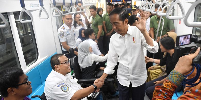 Presiden Joko Widodo (Jokowi) bersalaman dengan penyandang disabilitas saat mencoba menggunakan moda transportasi MRT, di Jakarta. 