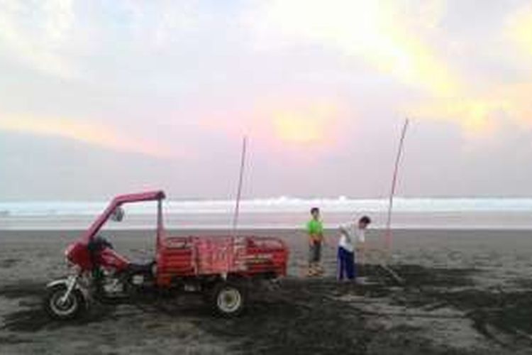 Sejumlah petugas yang sedang membersihkan sampah area pantai Parangtritis, Kamis (9/6/2016), pasca banjir rob akibat air laut pasang yang terjadi dari siang hingga malam hari kemarin.