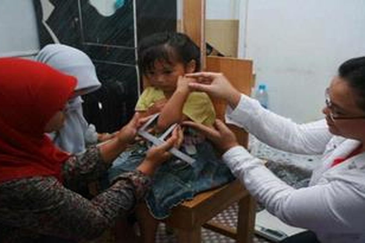 Tim peneliti sedang melakukan pengukuran anthopometry pada anak balita yang menjadi responden dalam studi SEANUTS di Kabupaten Pontianak, Kalimantan Barat.