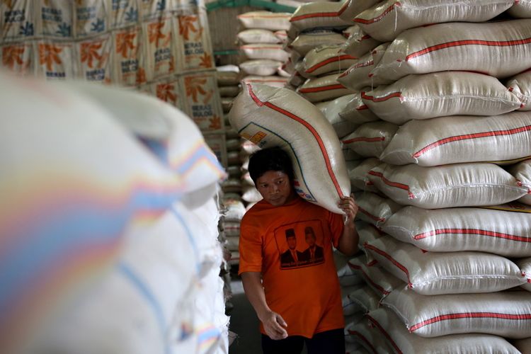 Buruh menurunkan beras Bulog di Pasar Induk Beras Cipinang, Jakarta Timur, Rabu (26/7/2017). 