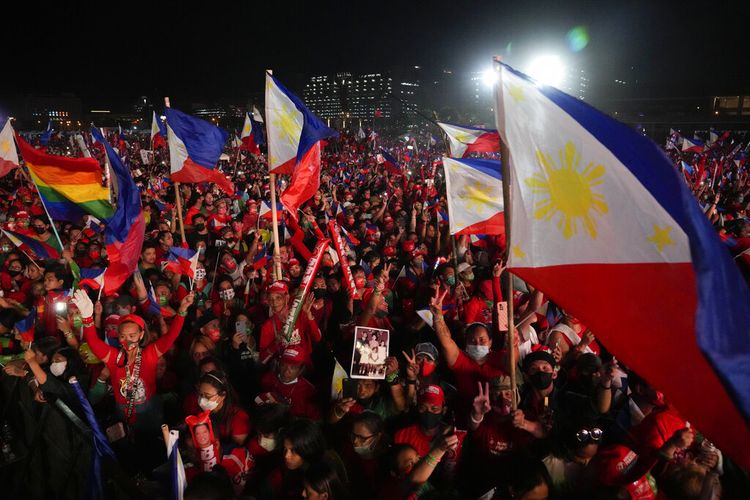 Pendukung calon presiden, Ferdinand Marcos Jr., putra mendiang diktator, mengibarkan bendera selama kampanye terakhir mereka yang dikenal sebagai Miting De Avance pada Sabtu, 7 Mei 2022 di kota Paranaque, Filipina. 