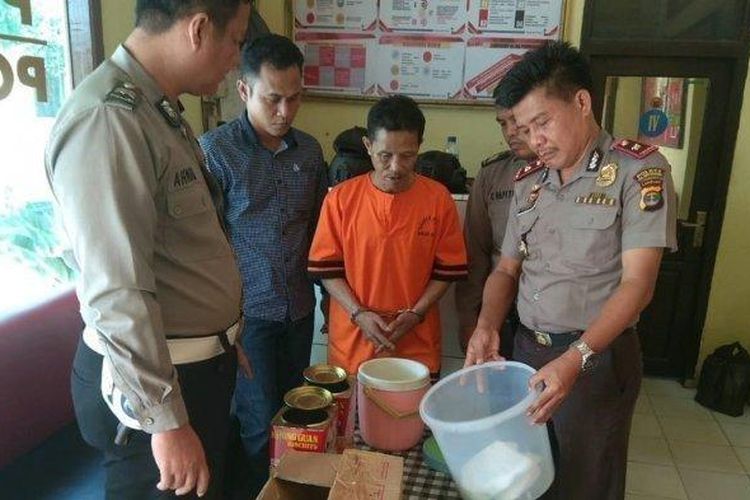 Dukun palsu bernama Sukijantoro (tengah) alias Guntoro bersama barang bukti yang diamankan polisi

