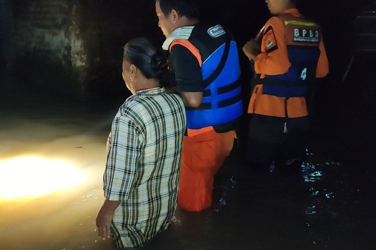 BPBD Kabupaten Cirebon Jawa Barat bersama TNI Polri memberikan bantuan kepada korban terdampak banjir, di Desa Gamel, Kecamatan Plered, Kabupaten Cirebon pada Selasa malam (20/12/2022)