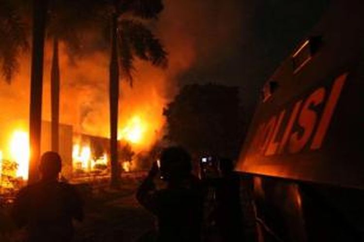 Polisi berjaga-jaga di kantor Lembaga Pemasyarakatan (Lapas) Klas I Tanjung Gusta, Medan, yang terbakar, Kamis (11/7/2013) malam. Lapas diduga dibakar sekelompok narapidana akibat adanya pemadaman listrik dan matinya air PDAM dalam Lapas. Diduga sekitar 300 napi berhasil kabur.
