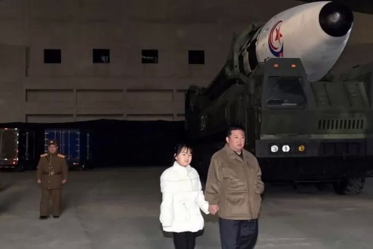 Salah satu foto yang dirilis KCNA pada 19 November Kim Jong Un dan putrinya sedang berjalan dengan latar belakang rudal antarbenua.