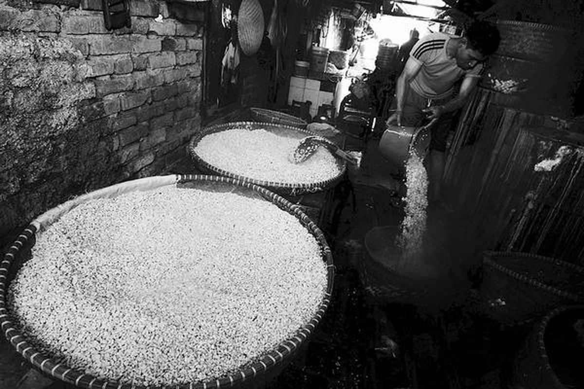 Nardi (23), perajin tempe di Cicadas, Bandung, Jawa Barat, tetap berproduksi, Rabu (25/7). Perajin menyesalkan tidak adanya kontrol pemerintah yang membantu mengatasi melambungnya harga kedelai. Sejak harga kedelai naik, perajin hanya bisa menyiasati dengan memperkecil ukuran produk.