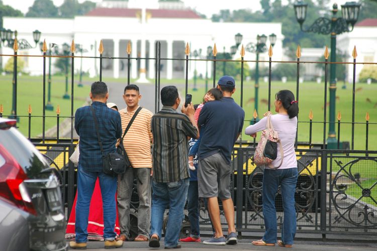 Sejumlah warga berfoto di depan gerbang utama pintu masuk Istana Bogor jelang kedatangan mantan Presiden Amerika Serikat Barack Obama, Jumat (30/6/2017).