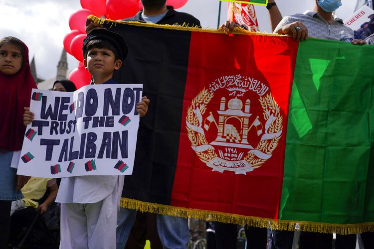 Demonstran memegang bendera Afghanistan, selama protes di Parliament Square, London, Rabu, 18 Agustus 2021.