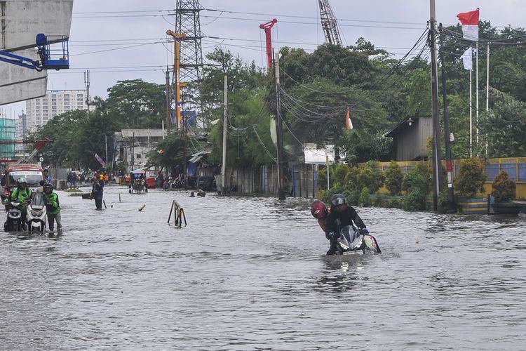 Sejumlah pengendara motor menerobos banjir di Pulogadung, Jakarta Timur, Minggu (23/2/2020). Curah hujan yang tinggi dan drainase yang buruk membuat daerah tersebut terendam banjir. ANTARA FOTO/Fakhri Hermansyah/wsj.