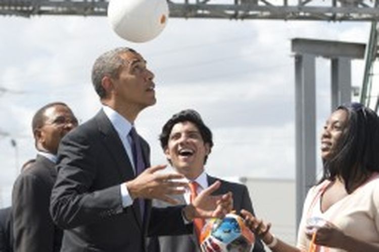 Presiden Barack Obama bermain soccet ball, sebuah bola yang bisa menghasilkan tenaga listrik dalam kunjungan kerjanya di Tanzania, Selasa (2/7/2013).