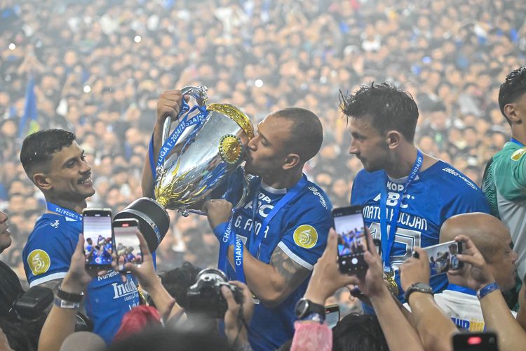 Bek Persib Bandung Gustavo Franca mencium piala Liga 1 2024-2025 dalam perayaan gelar back to back di Stadion Gelora Bandung Lautan Api (GBLA), Sabtu (24/5/2025).