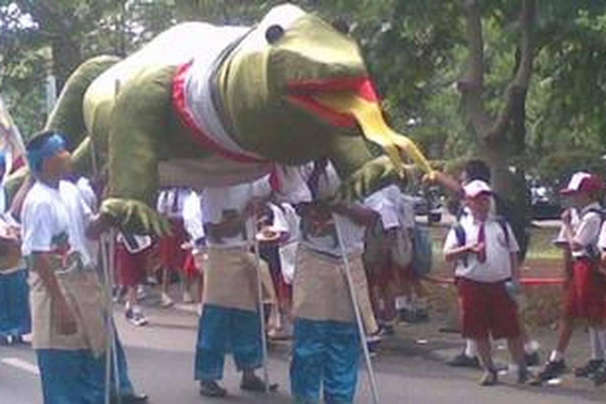 Replika Komodo yang digotong Anggota Sanggar Setia siap menyambut kedatangan Duta Komodo Indonesia Jusuf Kalla di Museum Satwa Indonesia, Komodo & Taman Reptilia TMII, Jakarta, Jumat (11/11/2011). Jusuf Kalla hadir di museum berarsitektur Komodo ini untuk menggalang dukungan terakhir bagi pemenangan komodo sebagai salah satu dari tujuh keajaiban dunia.
