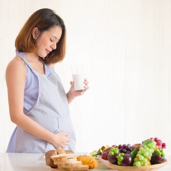 Ilustrasi ibu hamil menjaga kehamilan dengan mengonsumsi makanan dan minuman bernutrisi. 