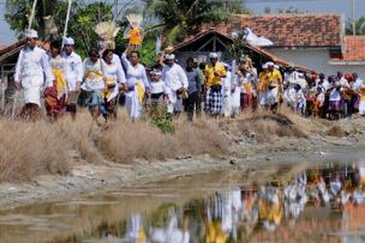 Ratusan warga Bali membawa sesajian ke pinggir laut di Desa Polagan, Kecamatan Galis, Pamekasan, dalam rangka upacara penyucian dewa laut, Senin (14/10/2013).