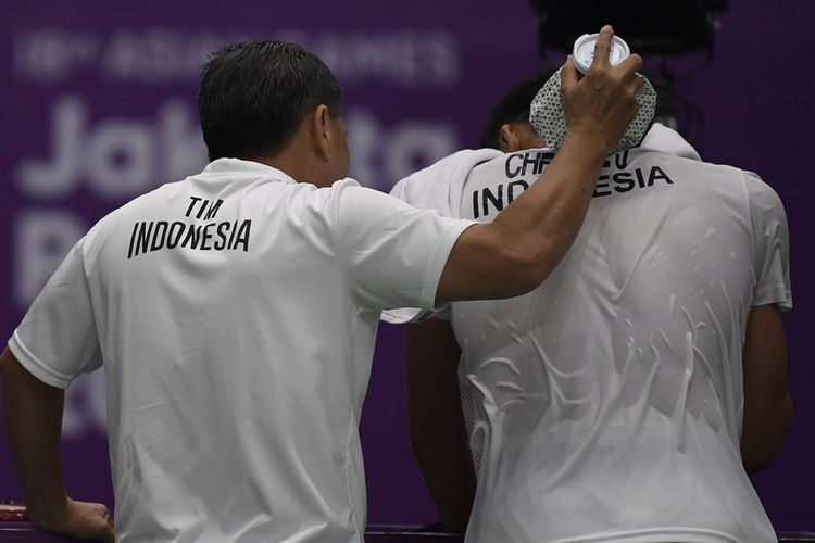 Pelatih tunggal putra Indonesia Hendry Saputra (kiri) memberi masukan pada pebulu tangkis tunggal putra Indonesia Jonatan Christie saat melawan pebulu tangkis tunggal putra China Taipei Chou Tien Chen pada babak final Asian Games XVIII di Istora Senayan, Jakarta, Selasa (28/8/2018). Setelah kerap mendapat cap buruk dalam sejumlah laga sebelumnya, Jojo sapaan akrab Jonatan membuktikan prestasinya dengan raihan emas di sektor tunggal badminton Asian Games 2018 serta fenomena aksi buka kausnya saat melakukan selebrasi.