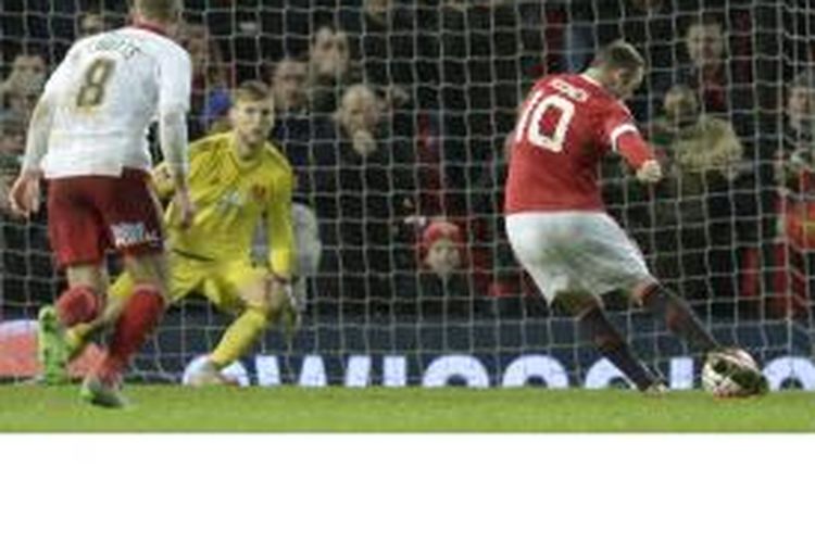 Striker Manchester United, Wayne Rooney (kanan), mencetak gol dari titik penalti ketika timnya menang 1-0 atas Sheffield United pada babak ketiga Piala FA di Old Trafford, Sabtu (9/1/2016).