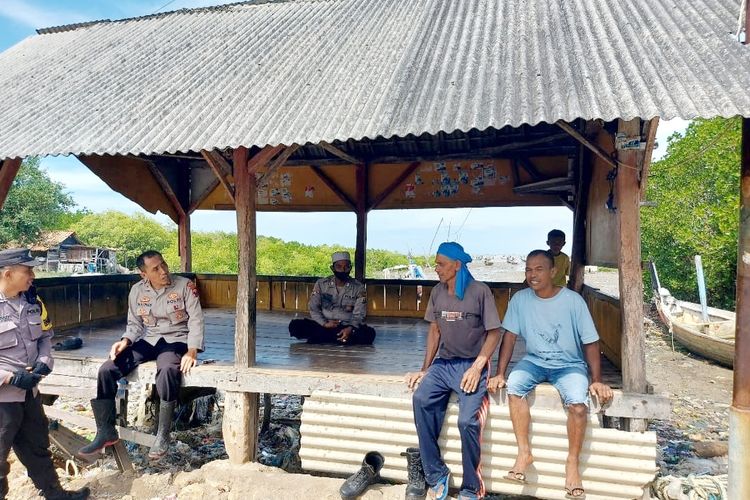 Anggota Polsek Pangarengan saat mendatangi nelayan di pesisir Desa Gulbung untuk mensosialisasikan korban laka laut di Sekat Bali yang belum ditemukan, Minggu (6/7/2025). 