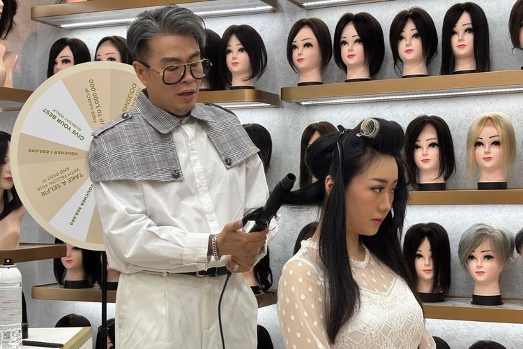 Hair stylist Indra Tanudarma mendemokan cara menata rambut yang menggunakan wig di acara pembukaan cabang kedua Beauty Crown di Kelapa Gading, Jakarta Utara (22/10/2025).