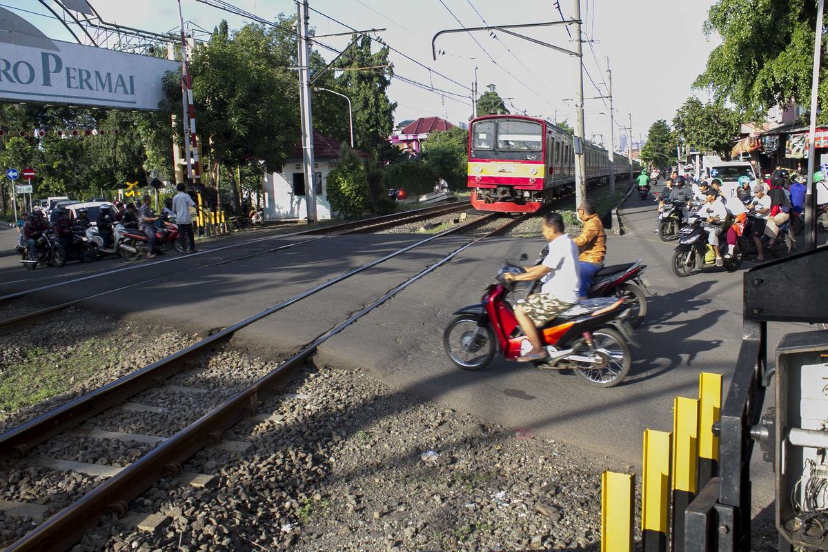 Pengendara melintas di perlintasan kereta api wilayah Bumi Bintaro Permai, Pondok Aren, Jakarta Selatan, Sabtu (22/2/2020). Tidak berfungsinya palang pintu di perlintasan kereta api sejak 2 tahun lalu mengancam keselamatan warga.