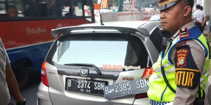 Pengemudi Honda Jazz bernama Wanda ditilang polisi karena kedapatan memiliki pelat ganda untuk menghindari aturan pembatasan kendaraan berdasarkan nomor pelat ganjil dan genap di Jalan Gatot Subroto, simpang Pancoran, Jakarta Selatan, Rabu (1/8/2018).