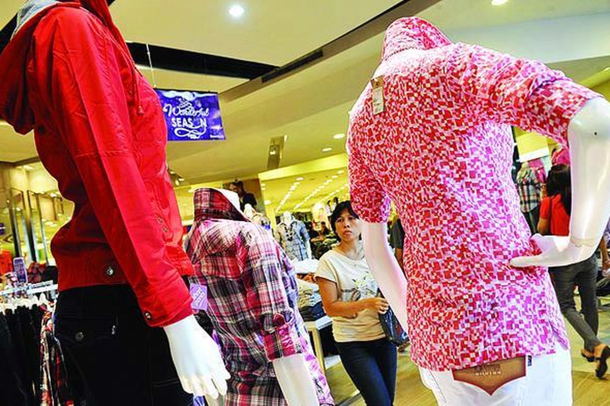 Pengunjung melihat pakaian yang dijual di pusat perbelanjaan di Jakarta Barat, Jumat (23/12). Uang yang dibelanjakan masyarakat kelas menengah Indonesia untuk pakaian dan alas kaki mencapai triliunan rupiah.