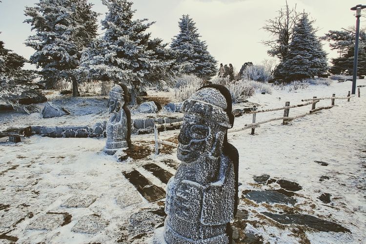 Patung batu Dol Hareubang di Pulau Jeju, Korea Selatan tertutup salju.