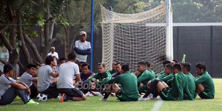 Pelatih timnas U-23 Indonesia, Luis Milla (ketiga dari kiri/menduduki bola), berbicara kepada para pemain sebelum memulai sesi latihan di Lapangan ABC, Senayan, Jakarta, Kamis (16/8/2018).
