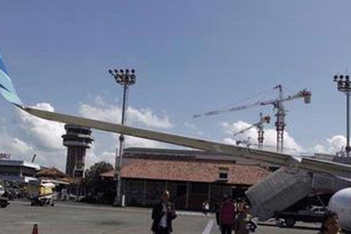 Wisatawan menuju pesawat Garuda Indonesia di Bandara Ngurah Rai, Bali, Kamis (11/4/2012). Garuda Indonesia akan terus meningkatkan layanan untuk mendukung program pemerintah Indonesia untuk mendatangkan satu jiwa wisatawan China ke Indonesia pada 2014.  