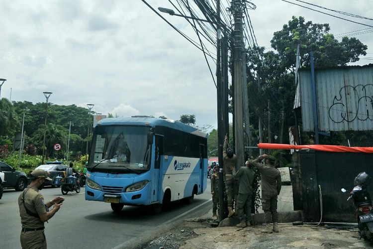 Satuan Polisi Pamong Praja (Satpol PP) Jakarta Selatan mencopot sejumlah atribut organisasi masyarakat (ormas) di sepanjang Jalan RS Fatmawati, Pondok Labu, Cilandak, Jakarta Selatan, Selasa (30/11/2021).