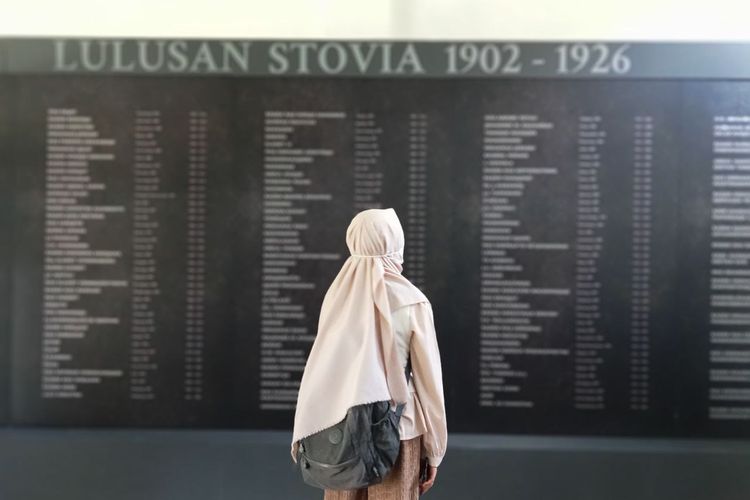 Potret pengunjung sedang melihat daftar lulusan Stovia di Museum Kebangkitan Nasional.