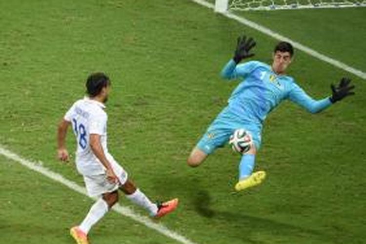 Kiper Belgia, Thibaut Courtois, mengantisipasi tembakan penyerang Amerika Serikat, Chris Wondolowski, pada laga 16 besar Piala Dunia, di Arena Fonte Nova, Salvador, 1 Juli 2014.